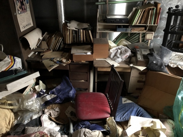 部屋に散乱した本と家具の山