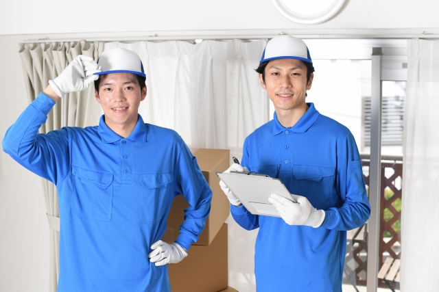 青い作業服で仕事をする二人の男性