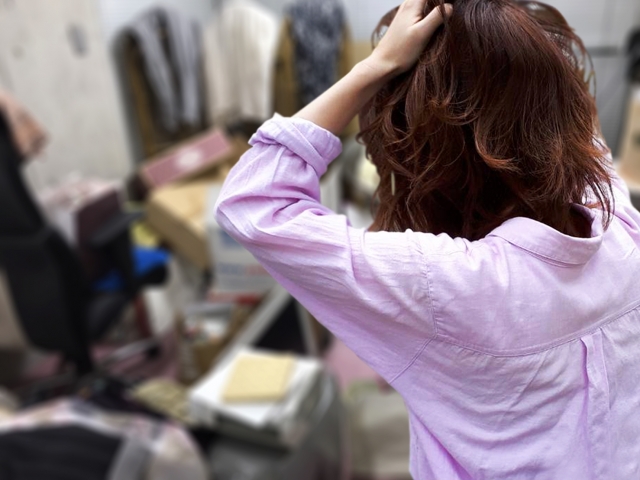 部屋で髪を直すシャツ姿の女性